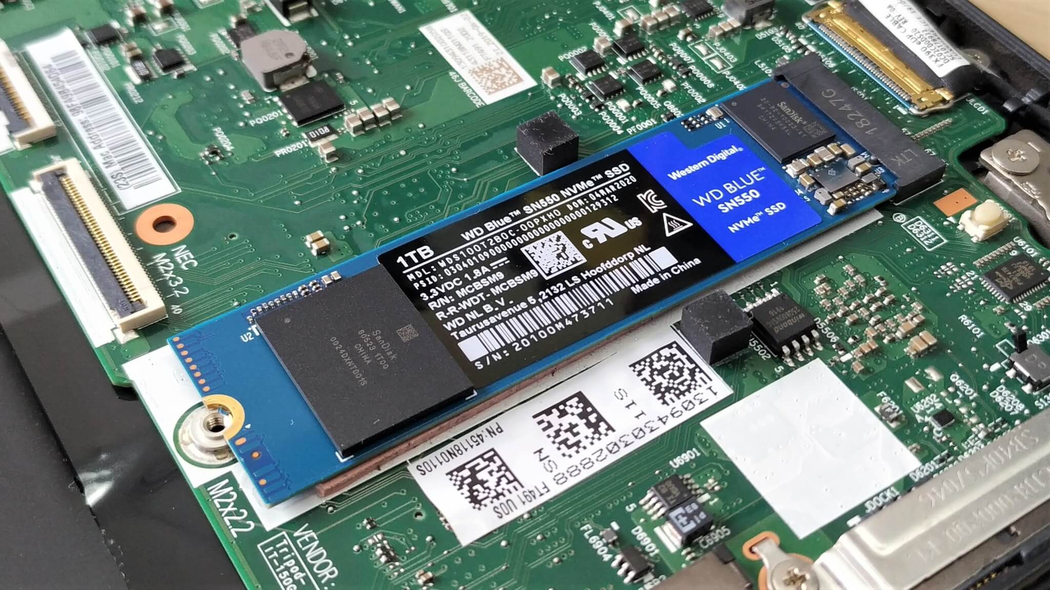 Thanh SSD M.2 NVMe gắn vào khe trên bo mạch laptop khi tháo nắp đáy nâng cấp